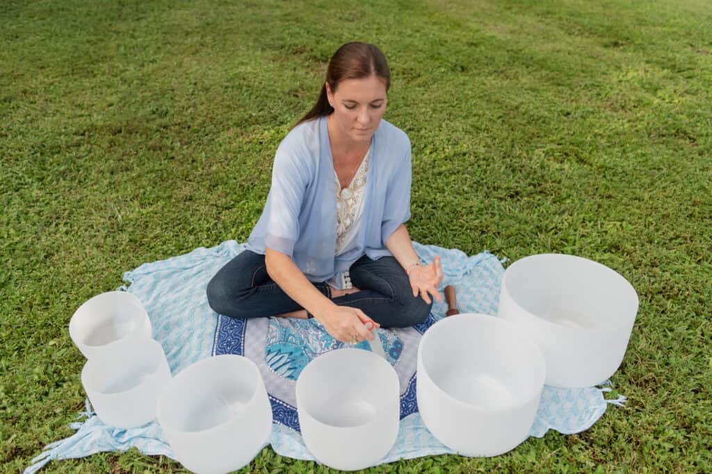 woman,practicing,meditation,using,crystal,bowls