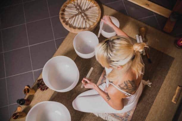 adult woman playing singing crystal bowl