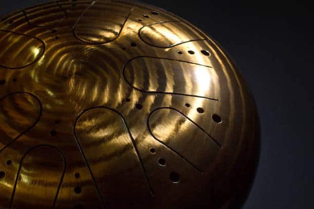 golden hang drum on a black background, near view, closeup