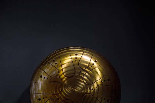 golden hang drum half on a black background, top view, copy space