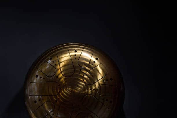 golden hang drum half on a black background, top view, copy space