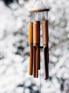 bamboo wind chimes hanging from roof in garden in winter with snow